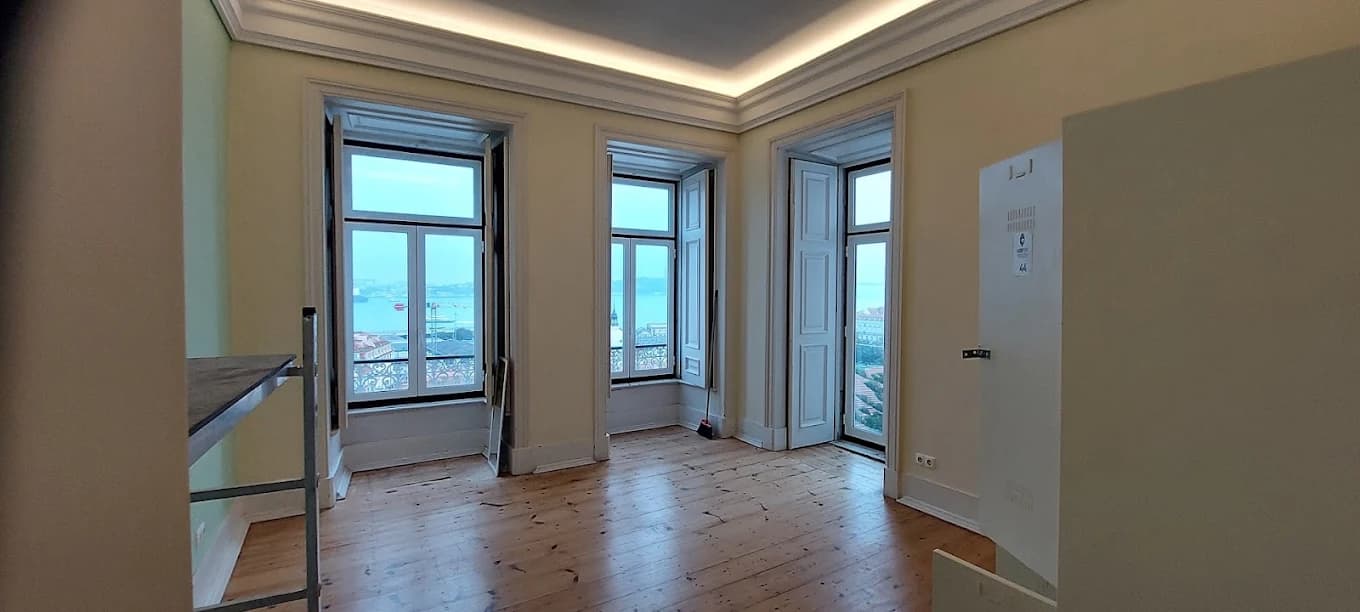 Sala remodelada com janelão e vista para o Tejo